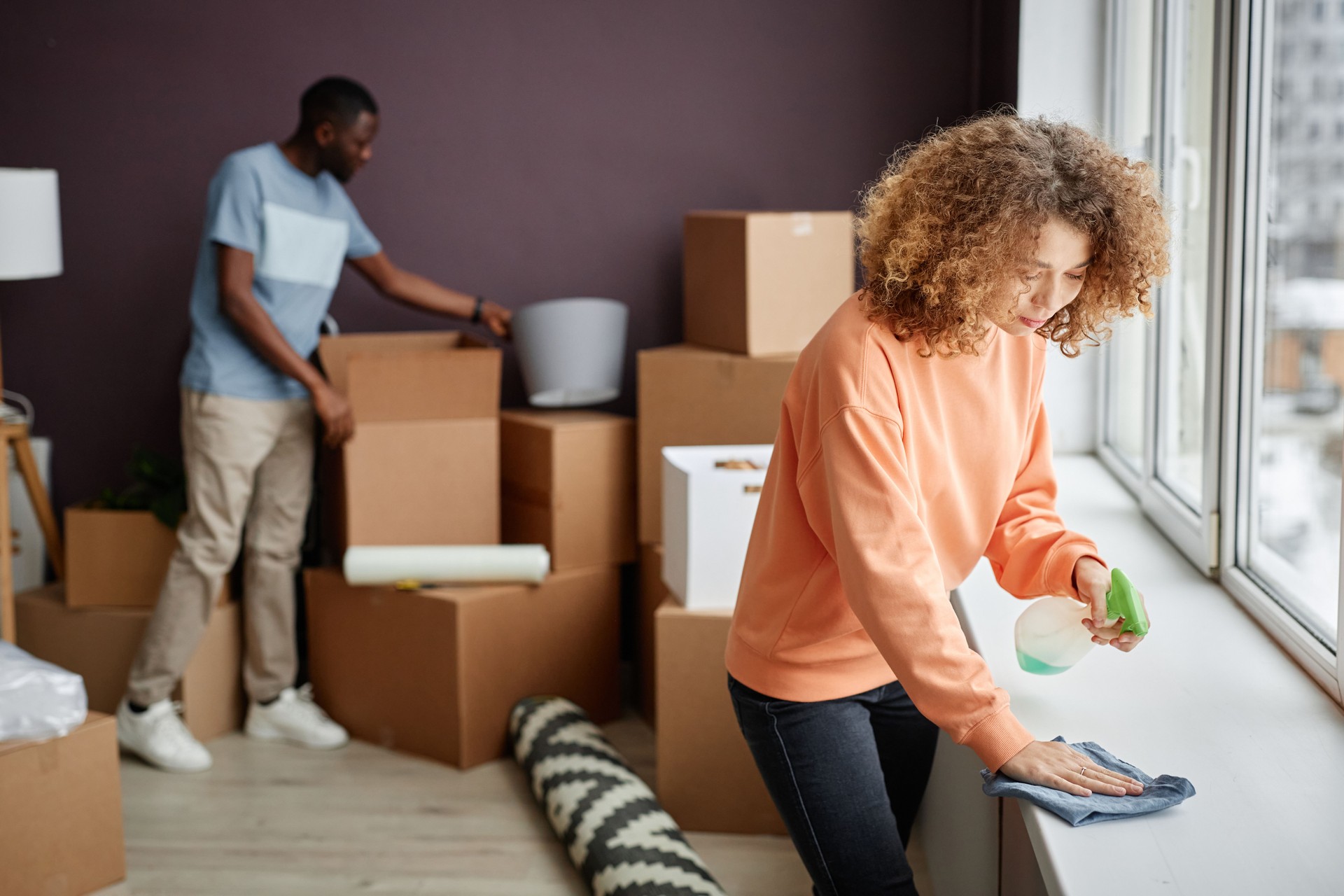 Young couple doing housework in the room Young couple doing housework in the room